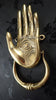 Hamsa hand door knocker in gold brass photographed on dark background showing details