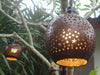Set of four coconut patio light shades glowing on outdoor string lights at night