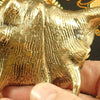 Hand holding brass sea shell hook showing handcrafted detail Bali artisan decor