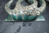 Base close-up of octopus tentacle door pull in green patina finish with mounting plate