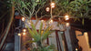 Round coconut shell lamp shade hanging outdoors on patio string lighting