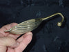 Curved hook detail of brass seashell wall hook for nautical and coastal interiors