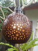 Tropical patio lights with coconut shell shades hanging over an outdoor seating area